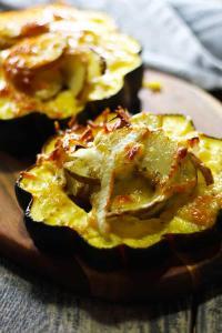 Janssons Temptation with Acorn Squash. A traditional Swedish smorgasbord potato side that is made during special occasions. Flavored with onions and anchovies, this version is served inside acorn squash and topped with Gruyere. This dish is AMAZING!! Both easy and delicious with multiple layers of flavor. Make this for your next potluck! | FusionCraftiness.com
