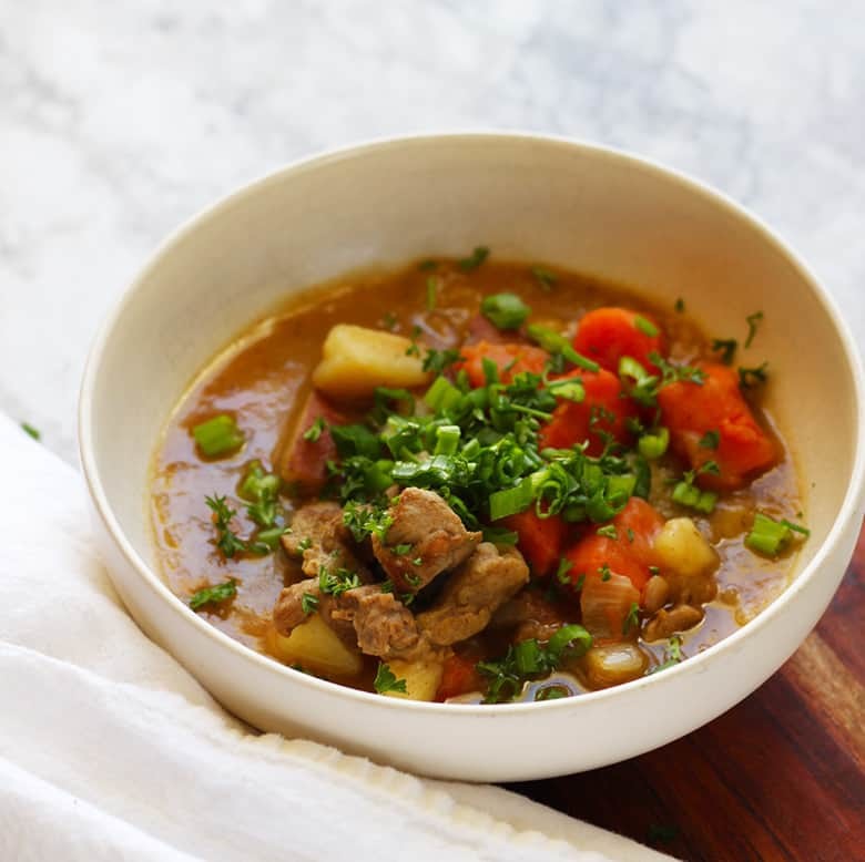 A bowl of Lamb Irish Stew garnished with fresh herbs.
