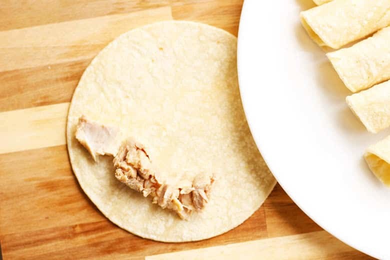 Easy Traditional Chicken Flautas Recipe. Just make your simple chicken filling, scoop on a corn tortilla, roll and shallow fry until golden brown. Serve with your favorite Latin American garnishes like salsa, guac, sour cream, cilantro & cheese.