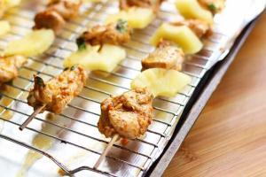 Skewers placed on a rimmed and lined baking sheet.