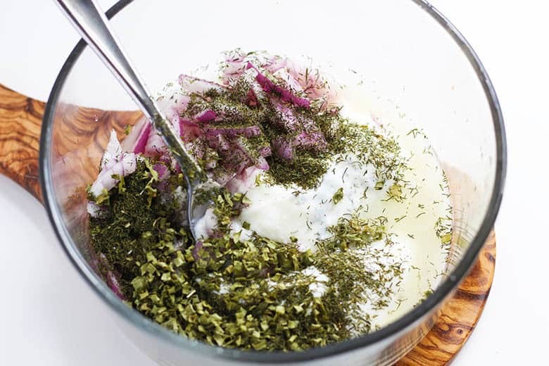 Yogurt, dill, onions and lemon juice in a mixing bowl.