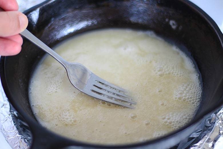 A cast iron skillet with oil and flour.