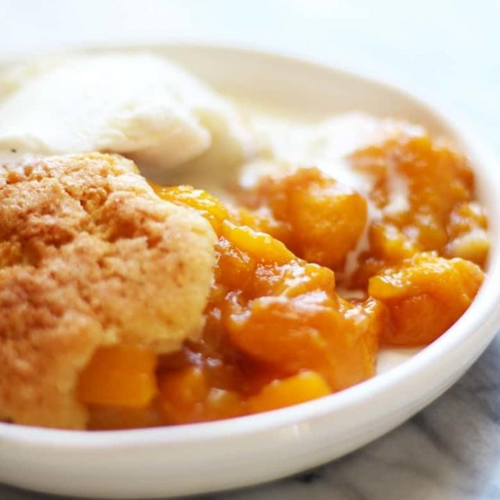 A bowl of French Peach Cobbler and ice cream.