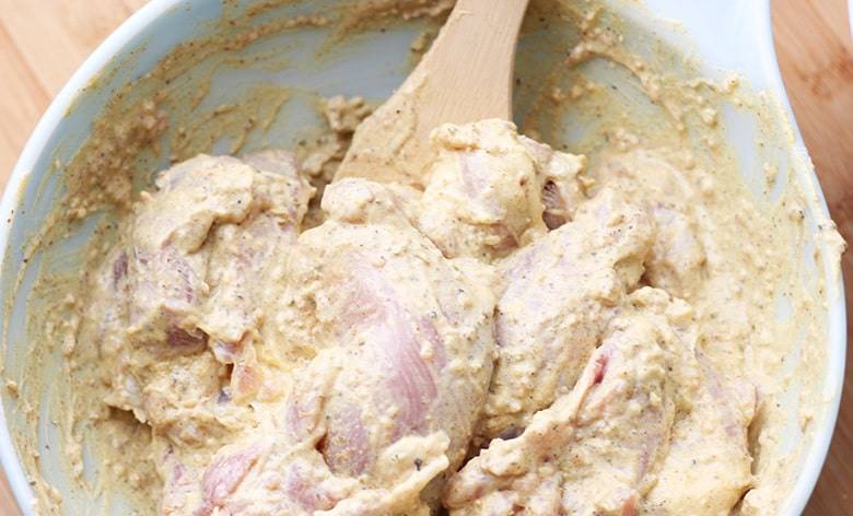 Chicken and marinade mixed in a bowl.