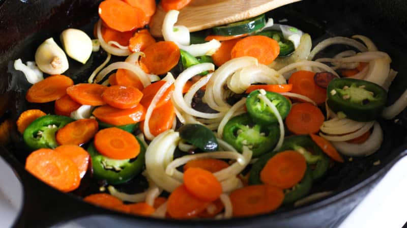 A skillet with vegetables.