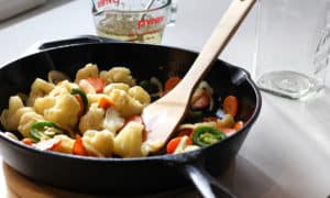 A cast iron skillet with vegetables in it.