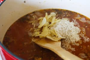 A soup pot with rice and potatoes.