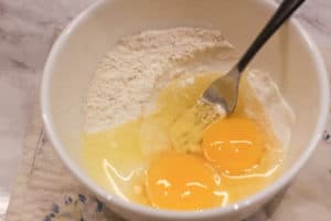 Eggs, salt and flour in a bowl.