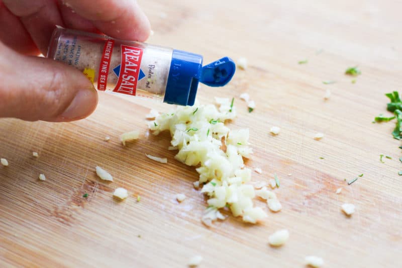 Salt sprinkled on chopped garlic.