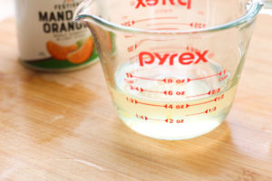 Mandarin juice from the can in a measuring cup.
