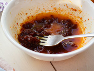 Gochujang sauce and melted butter in bowl.