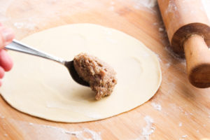 A scoop of meat filling on dough.