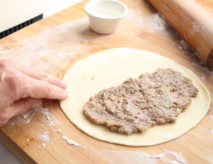 Meat filling on half of a dough round.