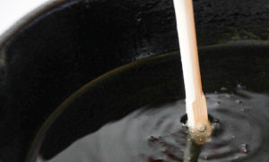 Chopstick in oil with bubbles.