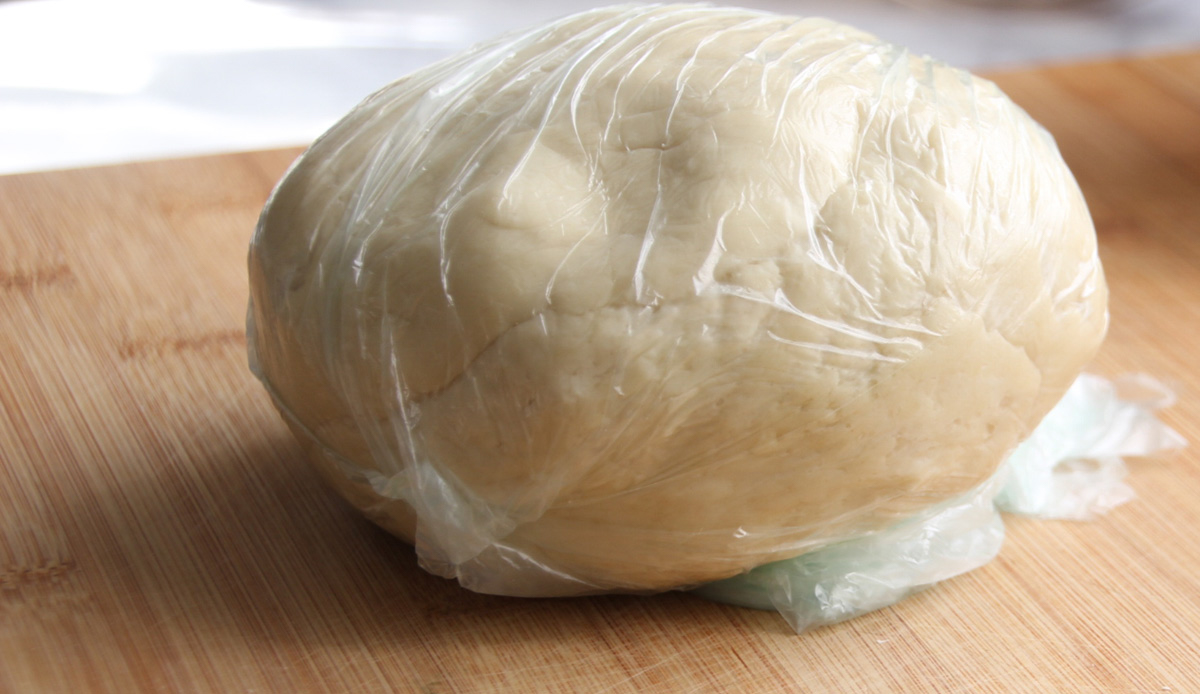 A ball of dough resting in plastic.